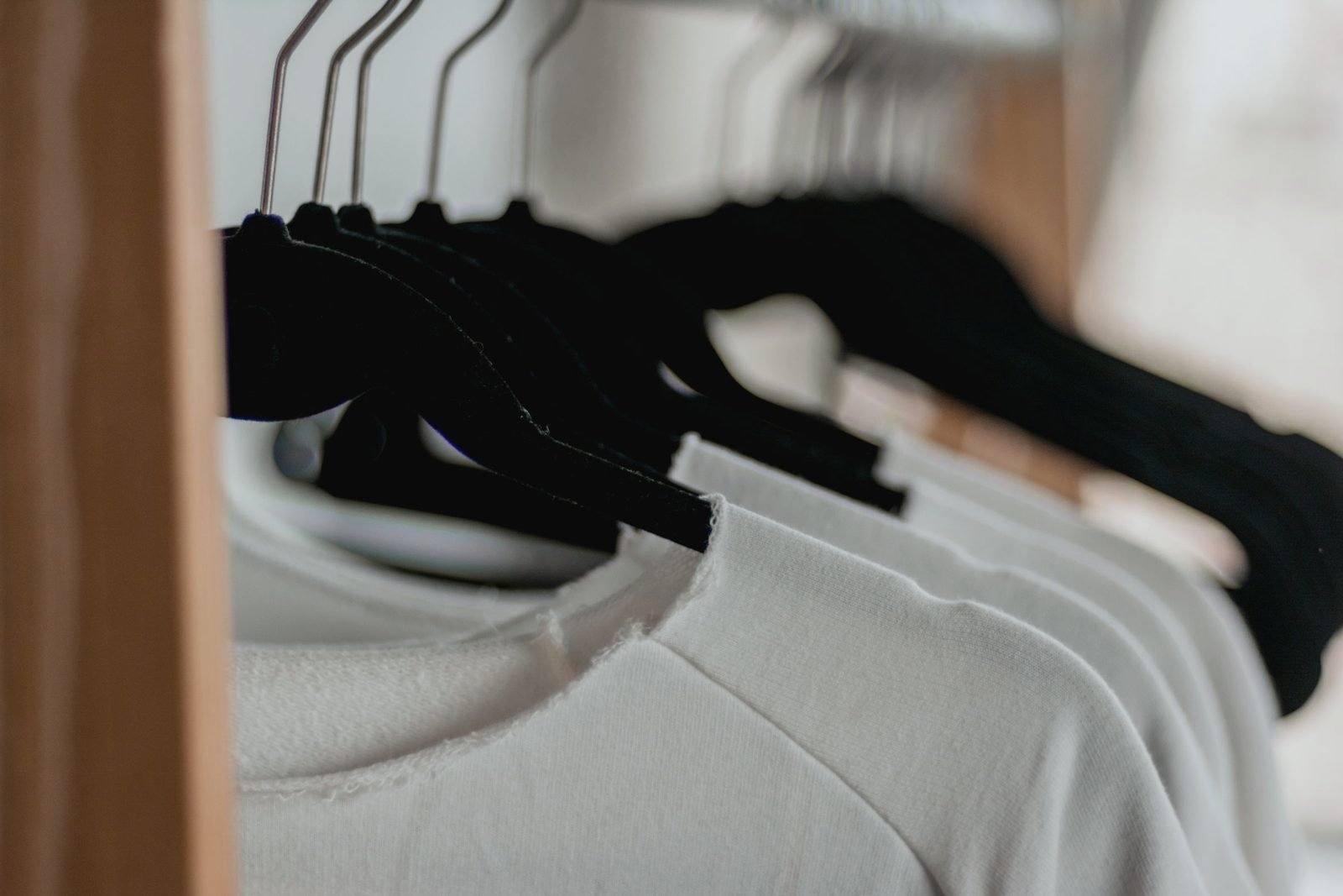 White shirts on black hangers along a rail